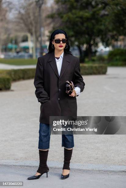 Maria Bernad wears hair band, oversized black striped blazer, cropped navy dark denim jeans, gauntlets, heels outside Zimmermann during Paris Fashion...