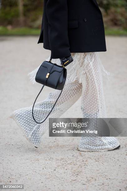 Charlotte Groeneveld wears black blazer, white laced dress, transparent pants, black Celine bag, sunglasses outside Zimmermann during Paris Fashion...
