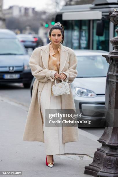 Bettina Looney wears beige fleece coat, high waisted skirt, brown blouse, Miu Miu bag, pointed heels outside Zimmermann during Paris Fashion Week -...