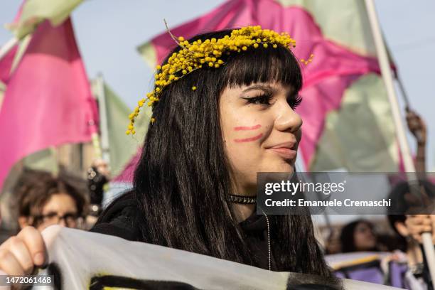 Student and feminist activist wearing a mimosa crown looks on as she takes part in a rally, demonstrating against gender violence and calling for...
