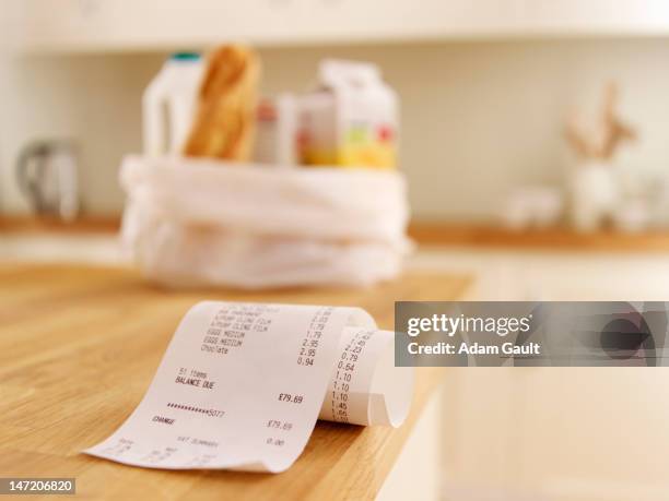 close up of grocery receipt on kitchen counter - bonnetje stockfoto's en -beelden