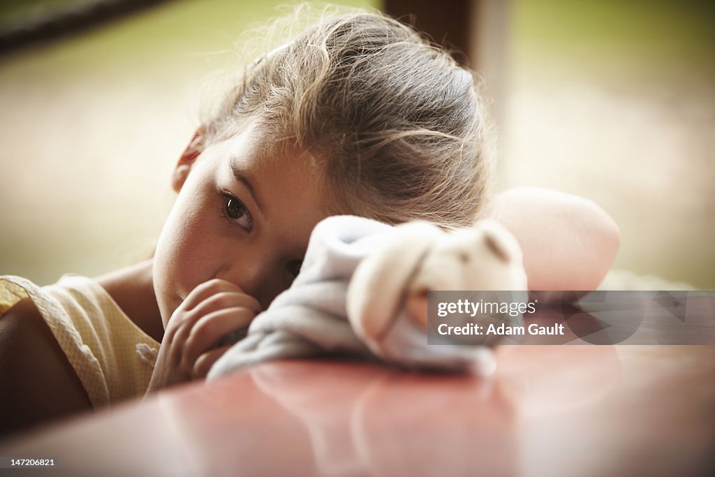 Close up of girl with stuffed animal sucking thumb