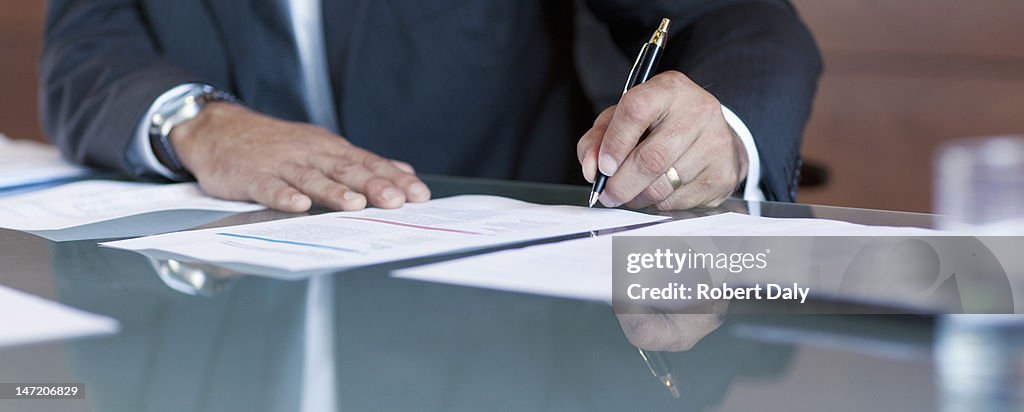 Businessman signing contract at table
