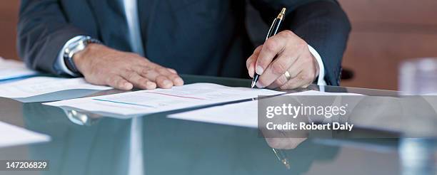 businessman signing contract at table - sign document stock pictures, royalty-free photos & images