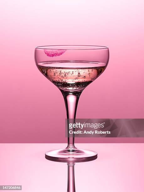 close up of pink champagne in glass with lipstick stain - pink lipstick stock-fotos und bilder