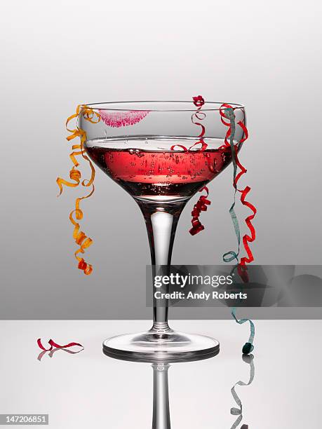 confetti hanging from glass of pink champagne with lipstick stain - pink lipstick smear stock pictures, royalty-free photos & images