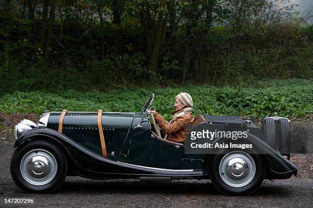 profile of senior woman in antique car - car country road photos et images de collection