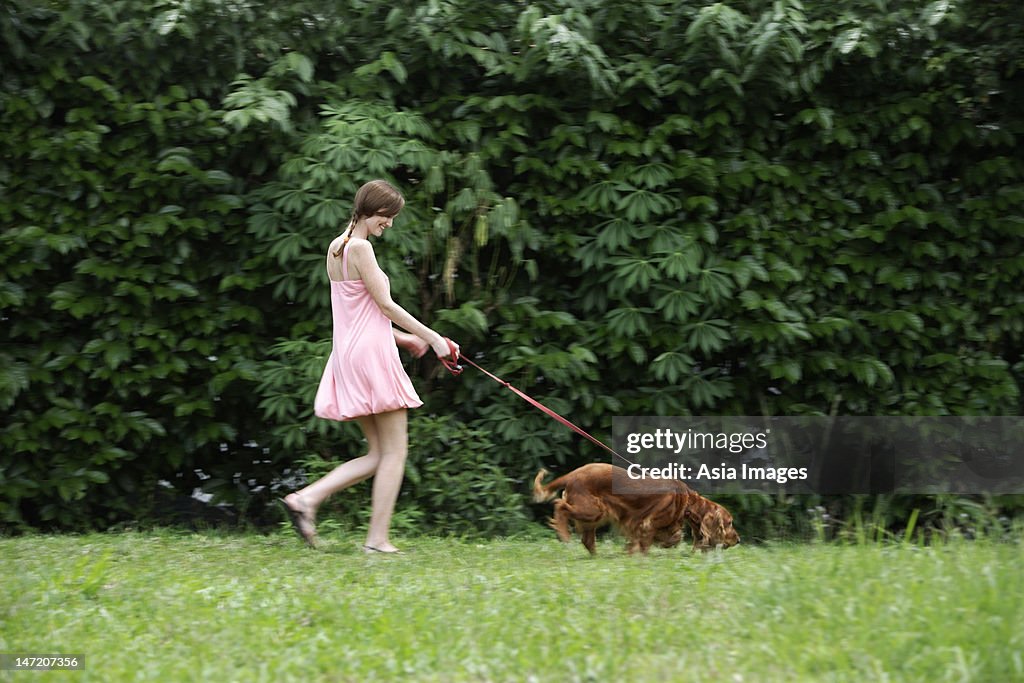 Young woman walking dog