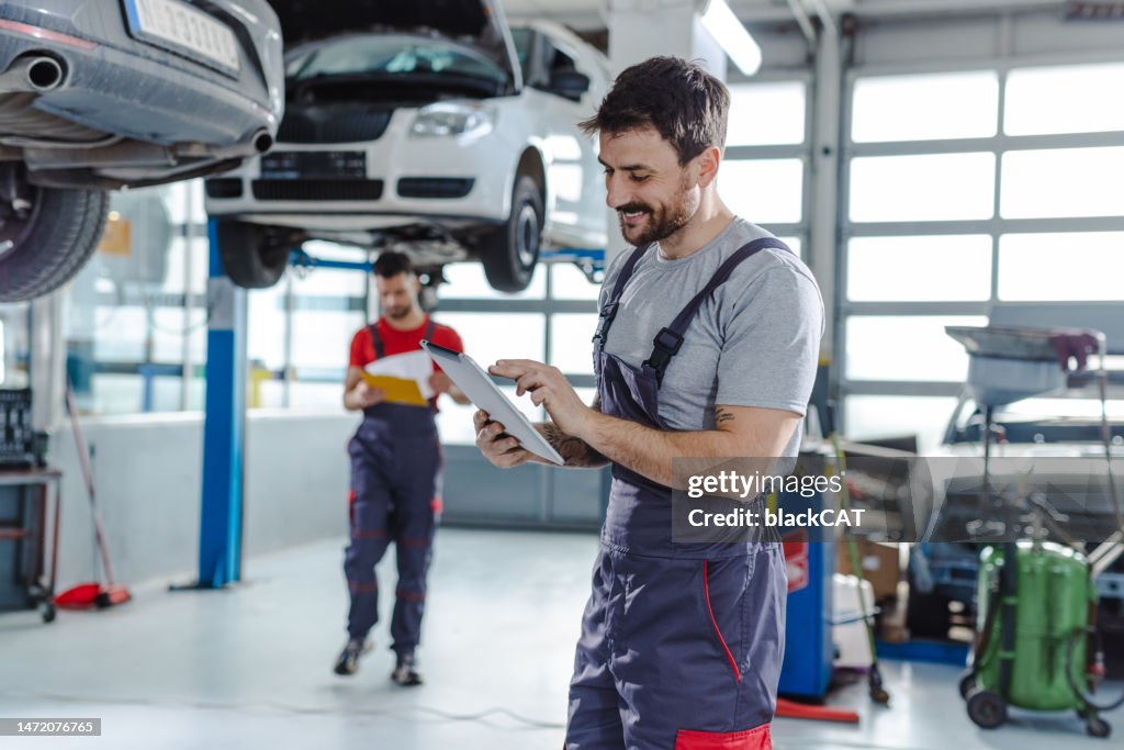 Técnicos automotivos na estação de serviço