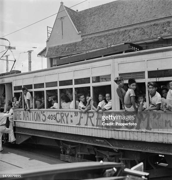 Local residents crowd on to a tram on a city street in Jakarta on the island of Java, after Indonesia's declaration of independence in the Dutch East...