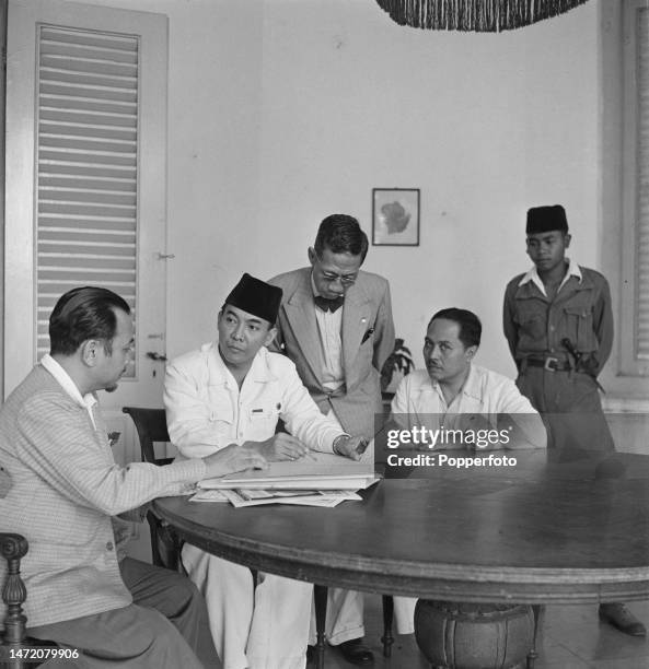 Indonesian statesman Sukarno , recently appointed President of Indonesia, seated 2nd from left heading a cabinet meeting with other government...
