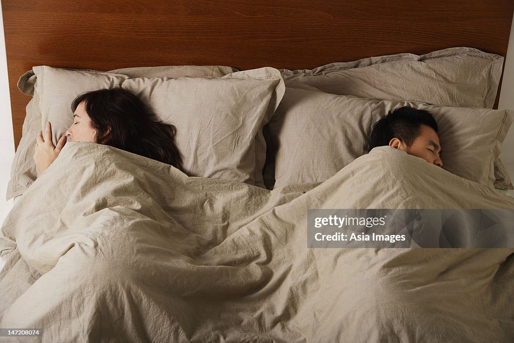 Man and woman sleeping in bed together