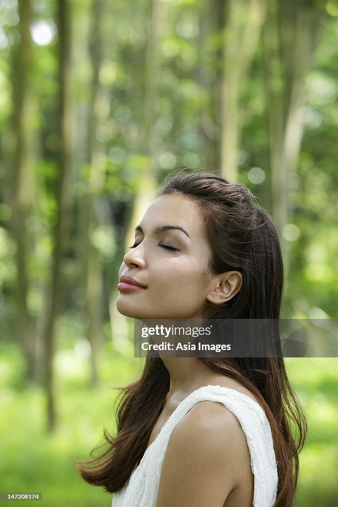 Head shot of young woman outside with eyes closed