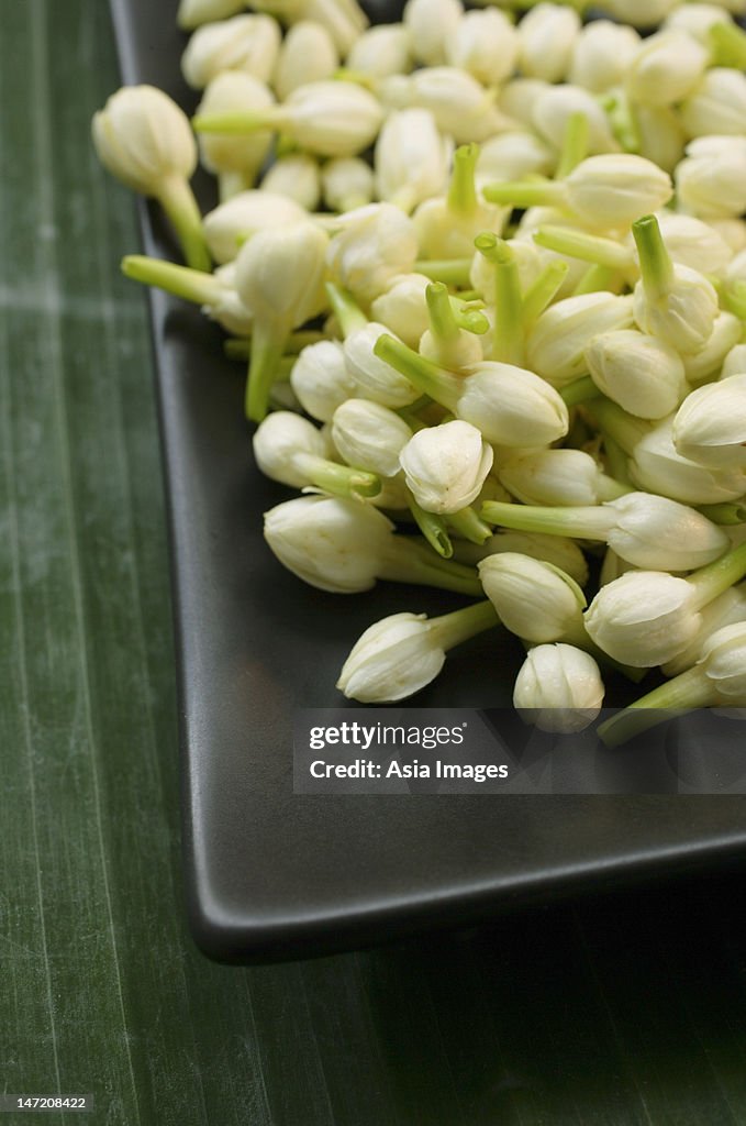 Jasmine blossoms on black platter
