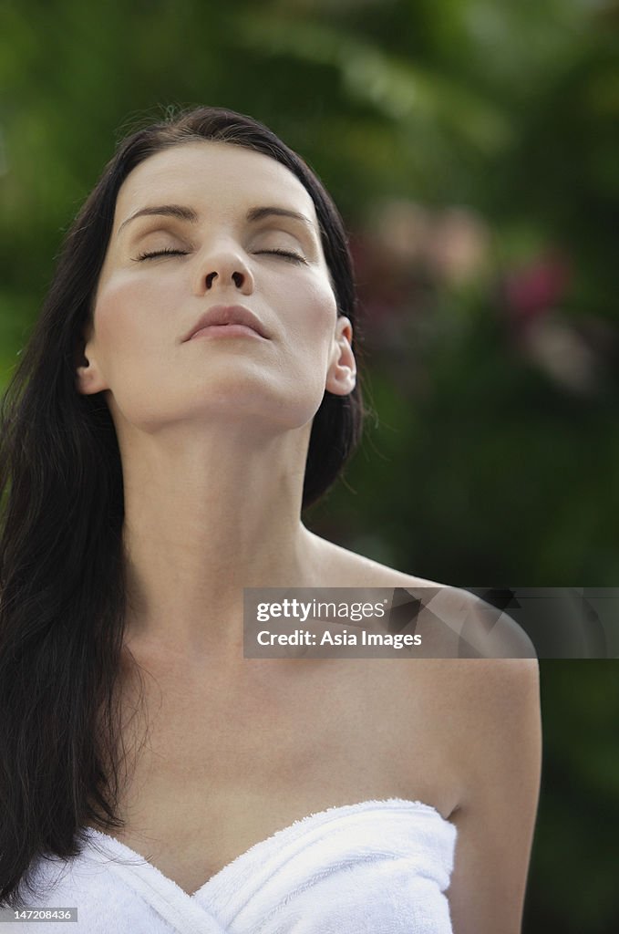 Woman wrapped in towel, face turned up