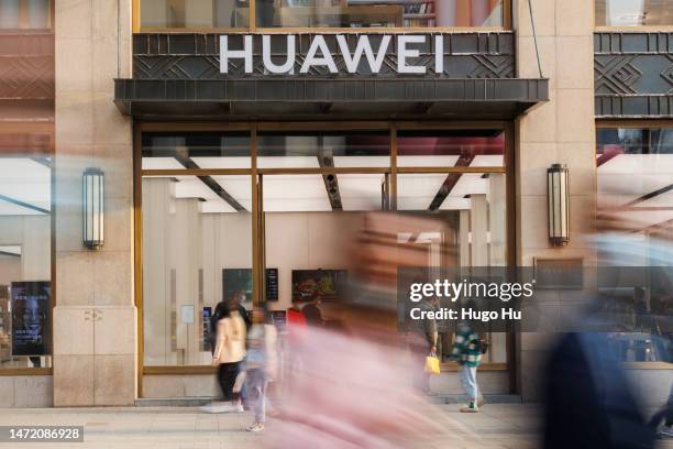 People walk in front of a Huawei store on Nanjing road on March 08, 2023 in Shanghai, China.
