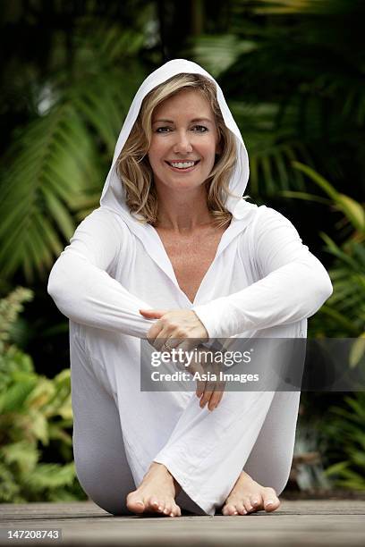 woman sitting on deck wearing all white - singapore spa stock pictures, royalty-free photos & images