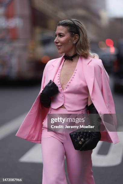 Olga Ferrara seen wearing Katandclerese black headpiece, Pharaoun Cocktail Rings colorful diamond earrings, black leather bow necklace, Maxara pink...