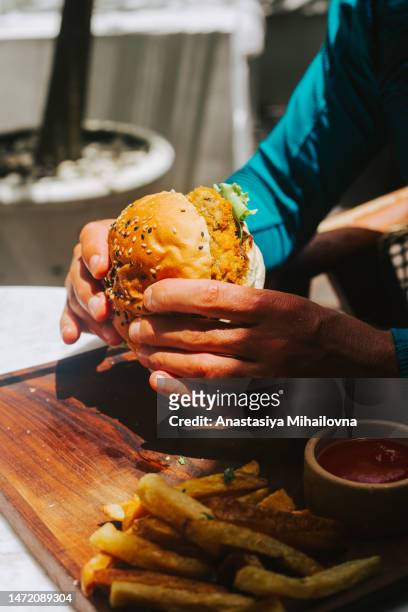 male hands holding burger with vegan cutlet side view - vegetable kebab stock pictures, royalty-free photos & images