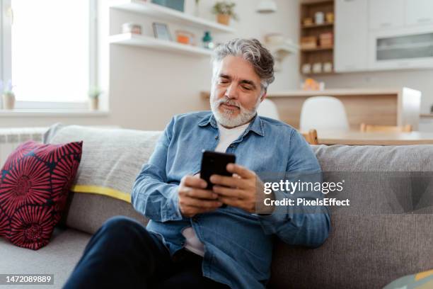 couch time is catching up time - middle aged man stock pictures, royalty-free photos & images