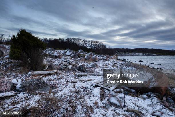 glacial erratics and driftwood on a snow covered beach on remote jurmo island in the turku archipelago baltic sea finland - turku finland stock pictures, royalty-free photos & images