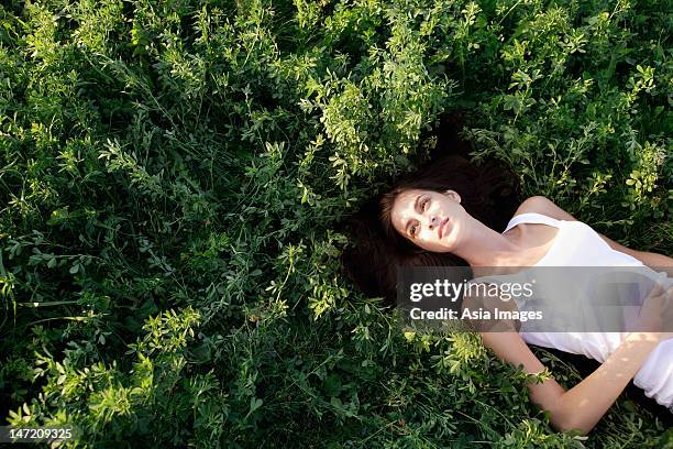 young woman lying on her back in field - eastern europe ストックフォトと画像