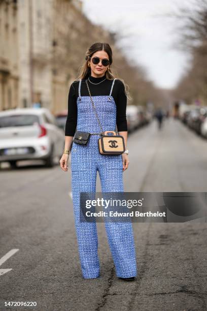 Paola Alberdi wears black sunglasses, gold earrings, a black wool turtleneck pullover, a rhinestones necklace, a royal blue and white tweed tank-top...