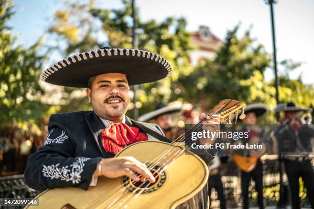 retrato de joven mariachi tradicional guitarrista al aire libre - mariachi fotografías e imágenes de stock
