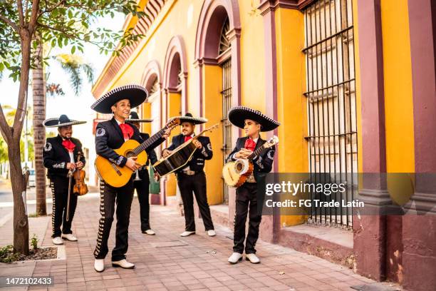 grupo de mariachis tradicionales caminando en el distrito histórico - mariachi fotografías e imágenes de stock