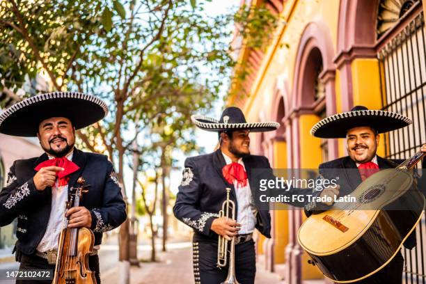 group of traditional mariachis walking at the historic district - mexican embroidery stock pictures, royalty-free photos & images