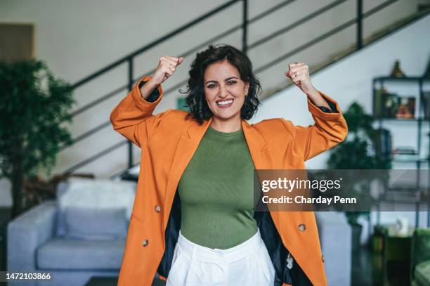 porträt einer aufgeregten geschäftsfrau, die sich im amt freut - orange jacke stock-fotos und bilder