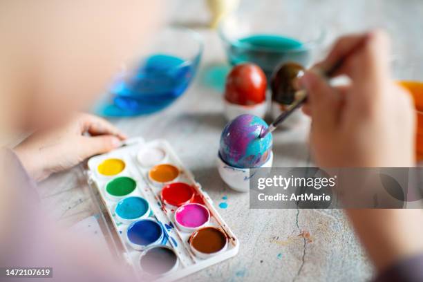 cute child  painting easter egg at home in springtime - konst och konshantverk bildbanksfoton och bilder