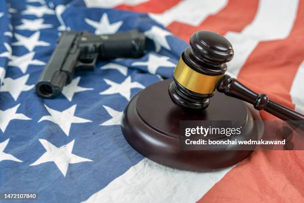 handgun with gavel on american flag. - american flag gun stock pictures, royalty-free photos & images