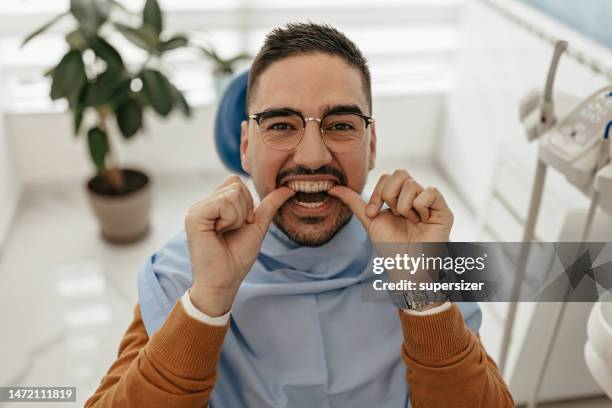 putting on my whitening dentures - braces stock pictures, royalty-free photos & images