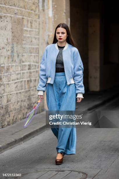 Guest wears wide leg denim jeans, blue jacket outside Rokh during Paris Fashion Week - Womenswear Fall Winter 2023 2024 : Day Eight on March 06, 2023...