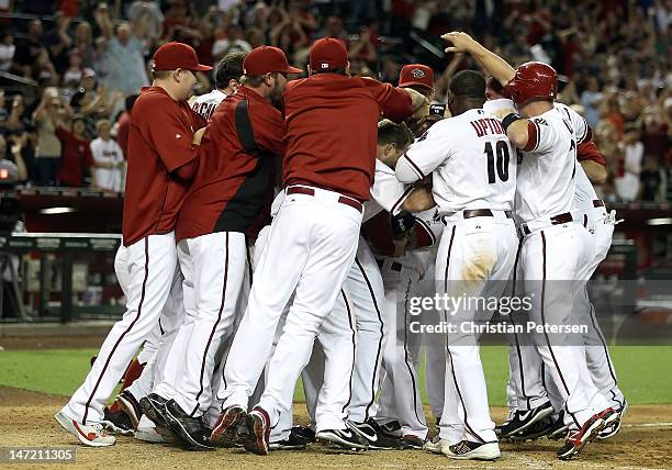 The Arizona Diamondbacks celebrate around Ryan Roberts after Roberts hit a walk off three-run home run against the Oakland Athletics during the ninth...