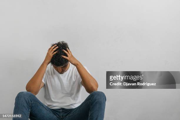 tired and downcast man holding head with hands. additions concept. - violence prevention stock pictures, royalty-free photos & images