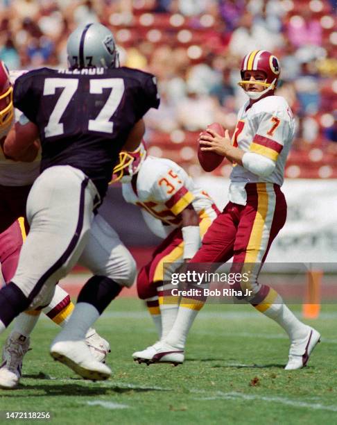 Redskins QB Joe Theismann under heavy pressure from Raiders Lyle Alzado during game between Los Angeles Raiders and Washington Redskins, August 18,...