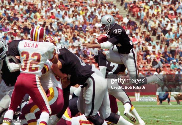 Raiders RB Marcus Allen dives over linemen near goal line to score a touchdown during game between Los Angeles Raiders and Washington Redskins,...