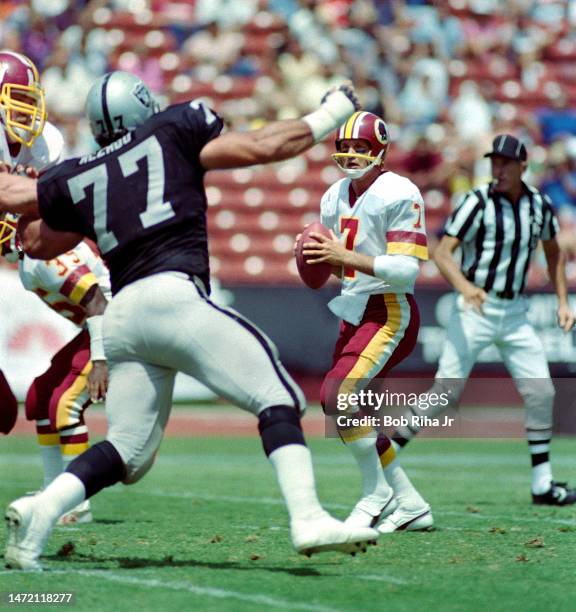 Redskins QB Joe Theismann under heavy pressure from Raiders Lyle Alzado during game between Los Angeles Raiders and Washington Redskins, August 18,...