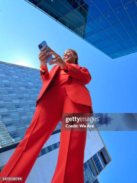 business woman in the city - woman entrepreneur looking at phone stock-fotos und bilder