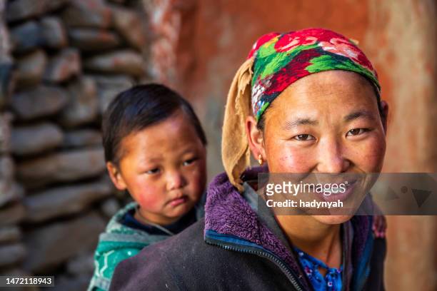 young tibetan woman carrying her baby girl, upper mustang - nepal girl stock pictures, royalty-free photos & images