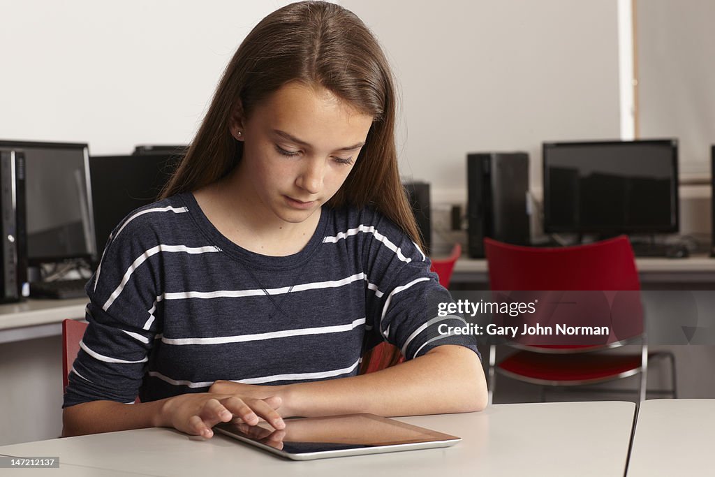 Schoolgirl( 12-14)using digital tablet