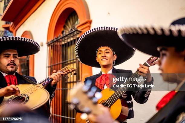 teenage boy traditional mariachi guitarist playing outdoors - mexican embroidery stock pictures, royalty-free photos & images