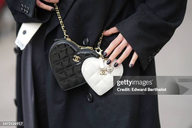 Chloe Harrouche wears a black long coat, a black shiny leather Heart crossbody bag from Chanel, outside Chanel, during Paris Fashion Week -...