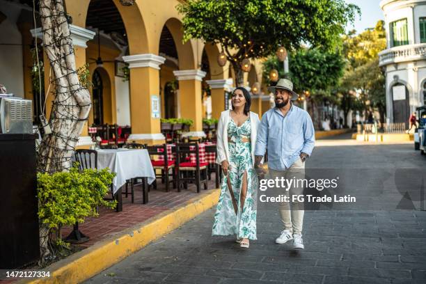 mid adult couple couple walking along the historic district - mazatlan mexico stock pictures, royalty-free photos & images