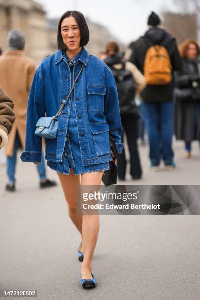 Eva Chen wears a navy blue denim jacket, a blue buttoned ripped short dress, a blue faded denim crossbody bag from Chanel, blue denim with black...