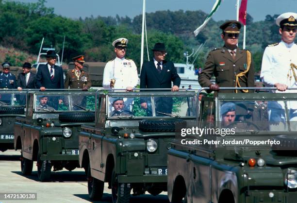 South African politician P W Botha , Minister of Defence, wearing a dark suit and glasses, rides in a convoy of Land Rover vehicles as part of a...