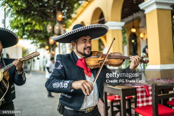 traditional mariachi violinist playing at the historic district - mariachi stock pictures, royalty-free photos & images