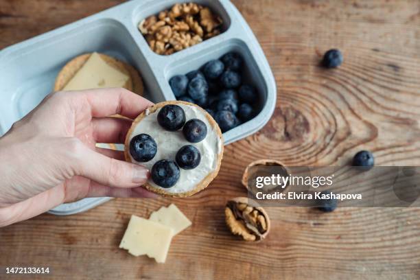 schoolboy lunchbox with avocado, cracker, cheese, blueberries and walnuts on a wooden background - lunch cheese foto e immagini stock